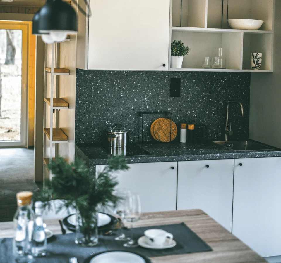 Kitchen of a Tiny House, fully furnished with all the extras. Tiny house kitchen, dining table, cutlery, and plates