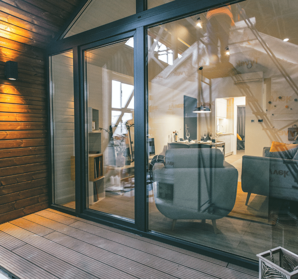 Tiny house with wooden porch and large glass window