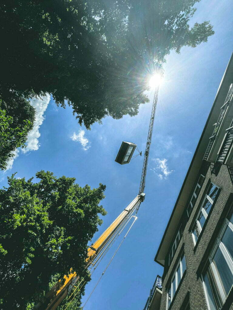 shot of a yellow crane lifting a tiny house