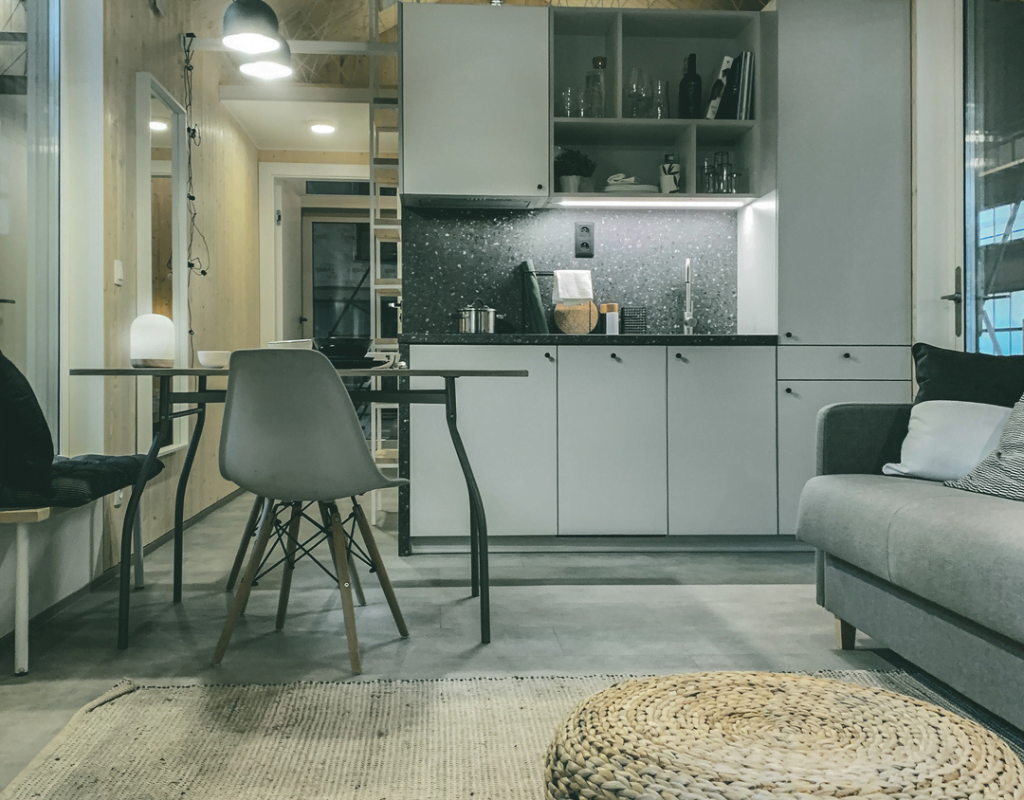 Malmö tiny house kitchen interior, table, chairs, pouf, couch, stairs to loft