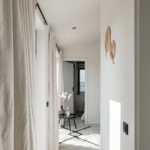 tiny house hallway, beige curtains, black chairs, white walls