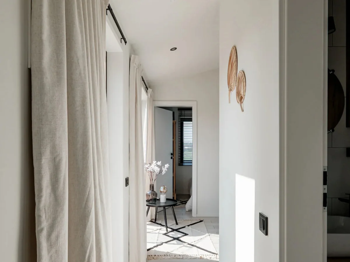 tiny house hallway, beige curtains, black chairs, white walls