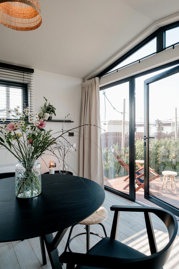 Tiny House Kitchen and Living Room, Black Table with Chairs, Glass Front with Beige Curtains